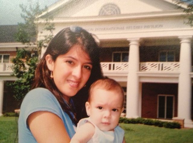 Maity Interiano' s sister in a blue vest holding a baby.